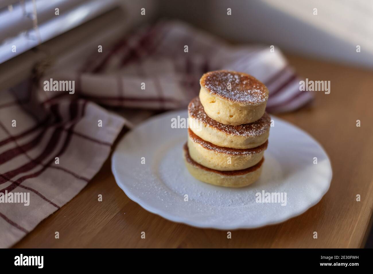 Frullato Pancake fatto in casa, mandorla, farina di cocco, chioseup, su piatto bianco con polvere dolce, asciugamano di cotone. Stile giapponese Dessert. Carbfree Ketogenic Foto Stock