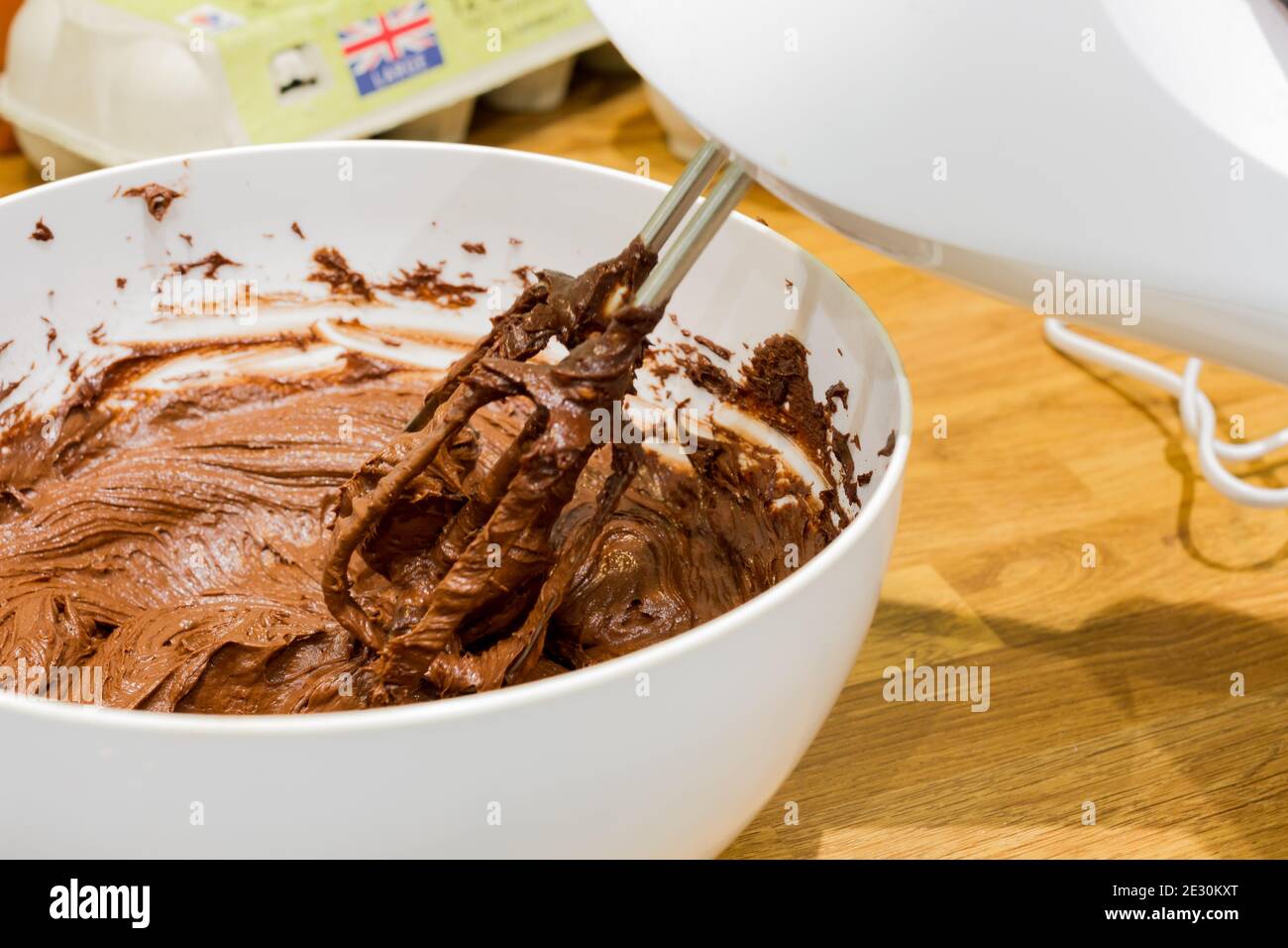 Pastella per torta al cioccolato in un recipiente con un closeup del miscelatore elettrico, Regno Unito Foto Stock