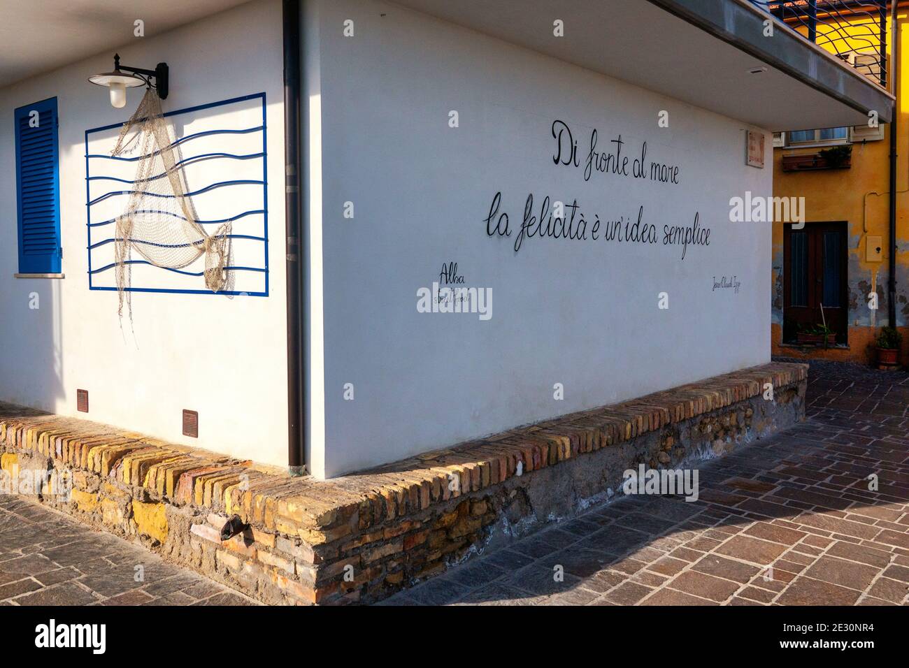 Scritta sul muro di una delle case di Silvi Paese. Si traduce come 'di fronte al mare, la felicità è una cosa semplice' Foto Stock