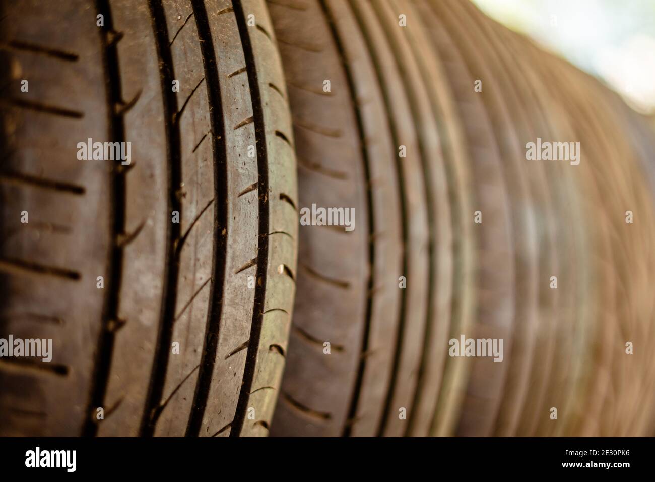 I vecchi pneumatici per auto si trovano su una rastrelliera in metallo nella officina di installazione Foto Stock