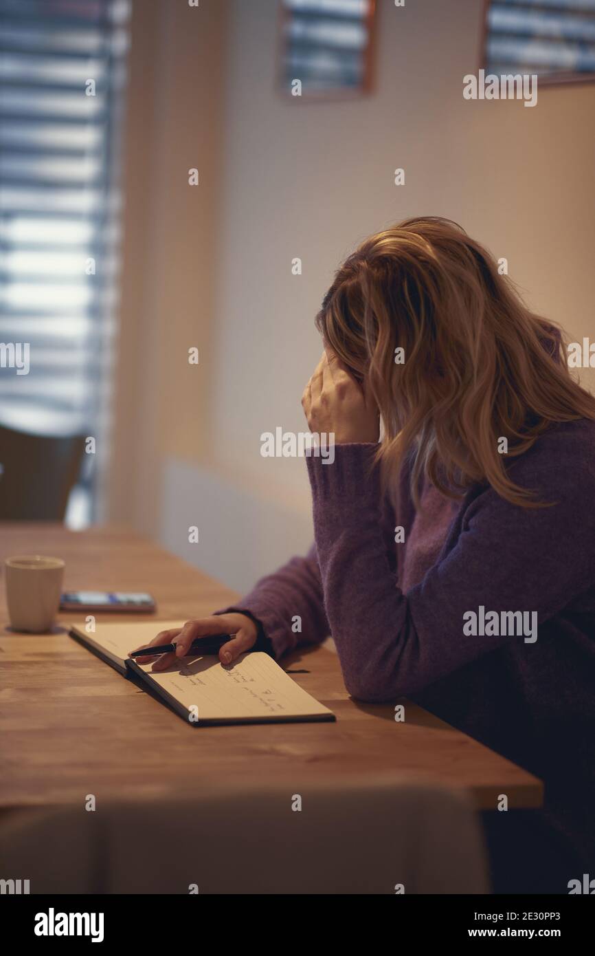 Donna scrittore in s piacevole atmosfera in cucina cercando di scrivere. Scrittura, mattina, ispirazione Foto Stock