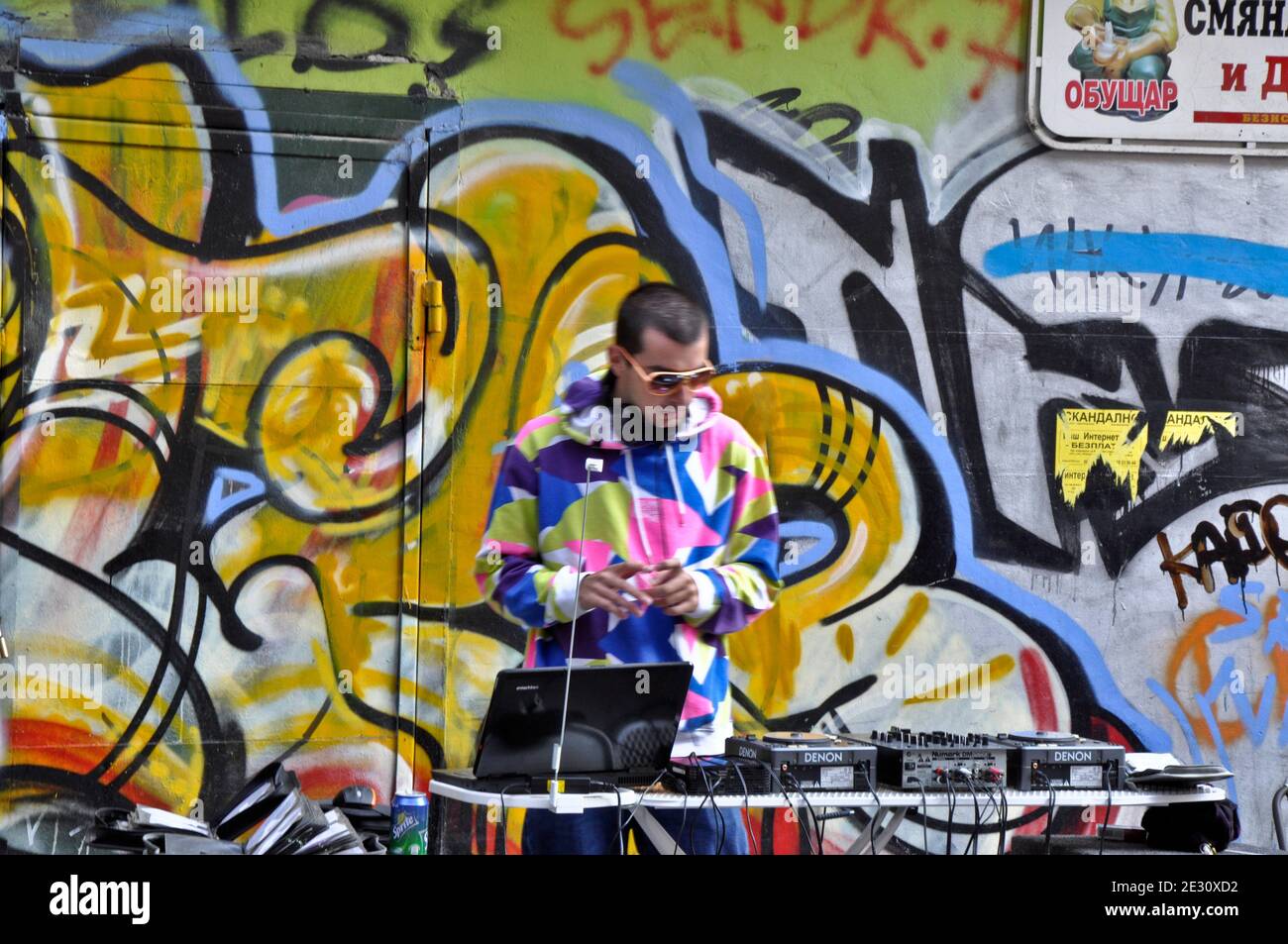 Lone DJ in vestito colorato che si esibisce dal vivo in un improvvisato DJ setup da graffiti murale per le strade durante il "Sofia respira" festival estivo di strada a Sofia Bulgaria Europa orientale Agosto 2010 Foto Stock