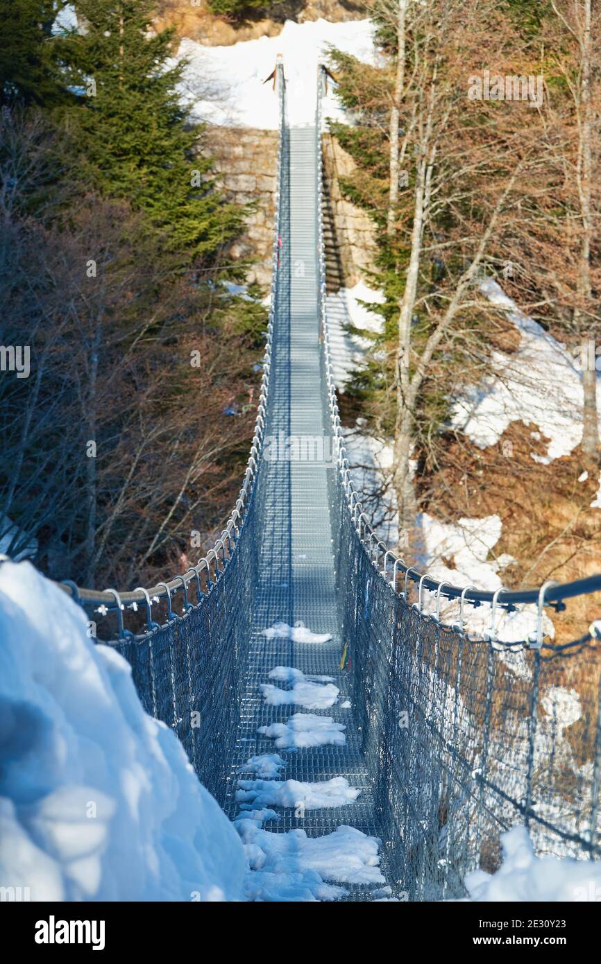 Ponte di metallo sospeso tibetano a Valli del Pasubio, in inverno Foto Stock