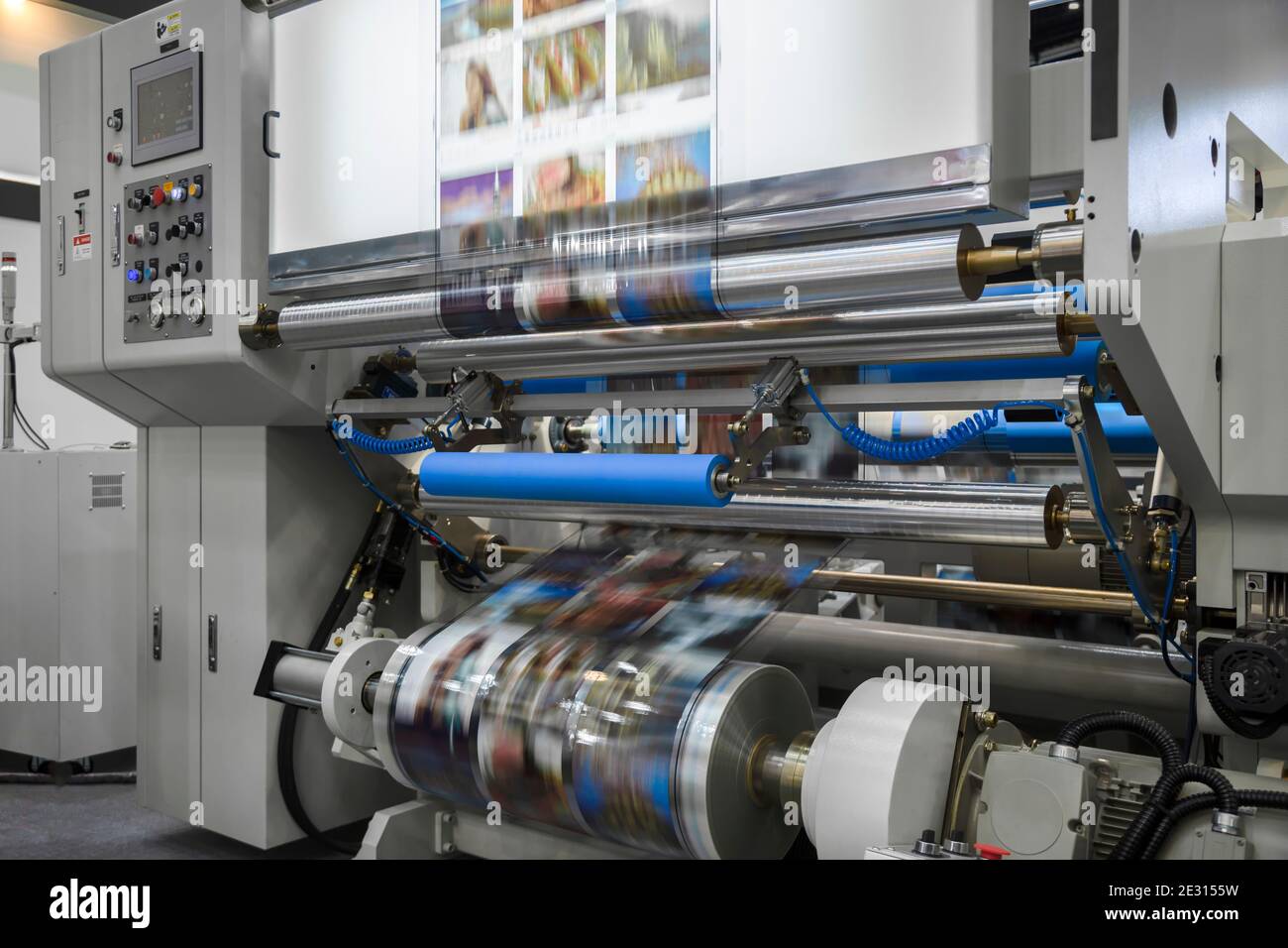 Stampante offset grande o caricatore che esegue un rotolo lungo di carta  nella linea di produzione della stampante industriale Foto stock - Alamy
