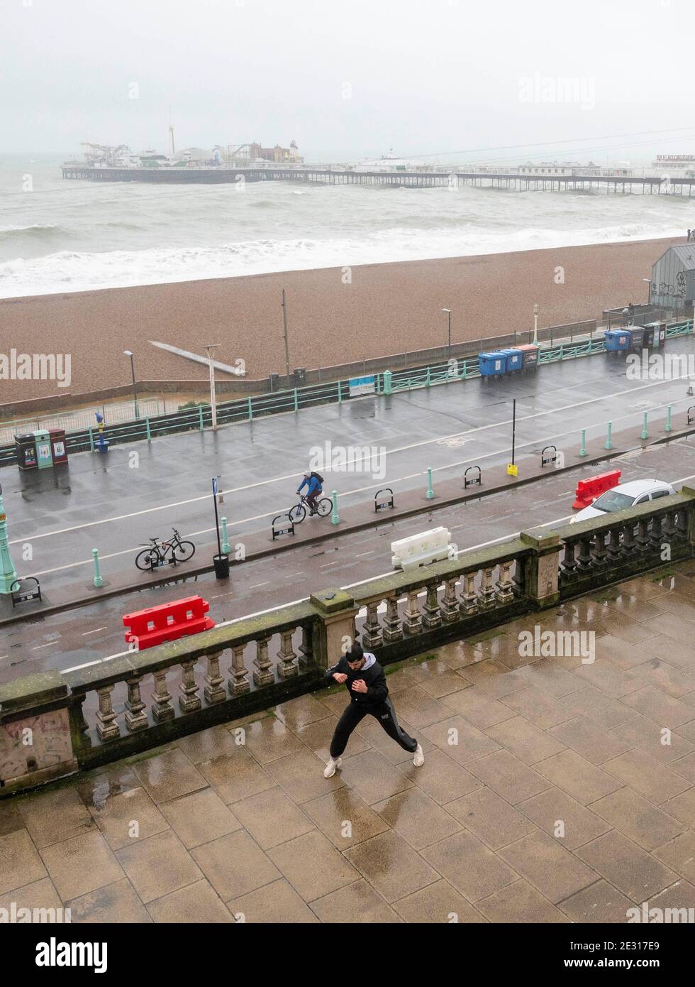 Brighton UK 16 gennaio 2021 - UN giovane passa attraverso il suo addestramento di boxe sul lungomare di Brighton in una giornata umida e ventosa lungo la costa meridionale, mentre le restrizioni di blocco del coronavirus COVID-19 continuano in Inghilterra . : Credit Simon Dack / Alamy Live News Foto Stock