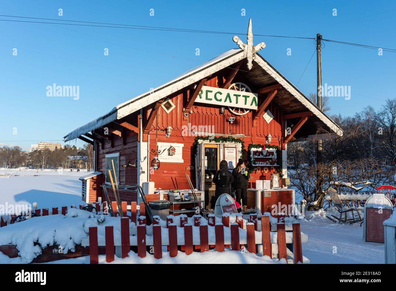 Café Regatta, una piccola cabina di legno rosso di oltre 120 anni sulle rive di Taivallahti con posti a sedere all'aperto, durante l'inverno a Helsinki, Finlandia Foto Stock