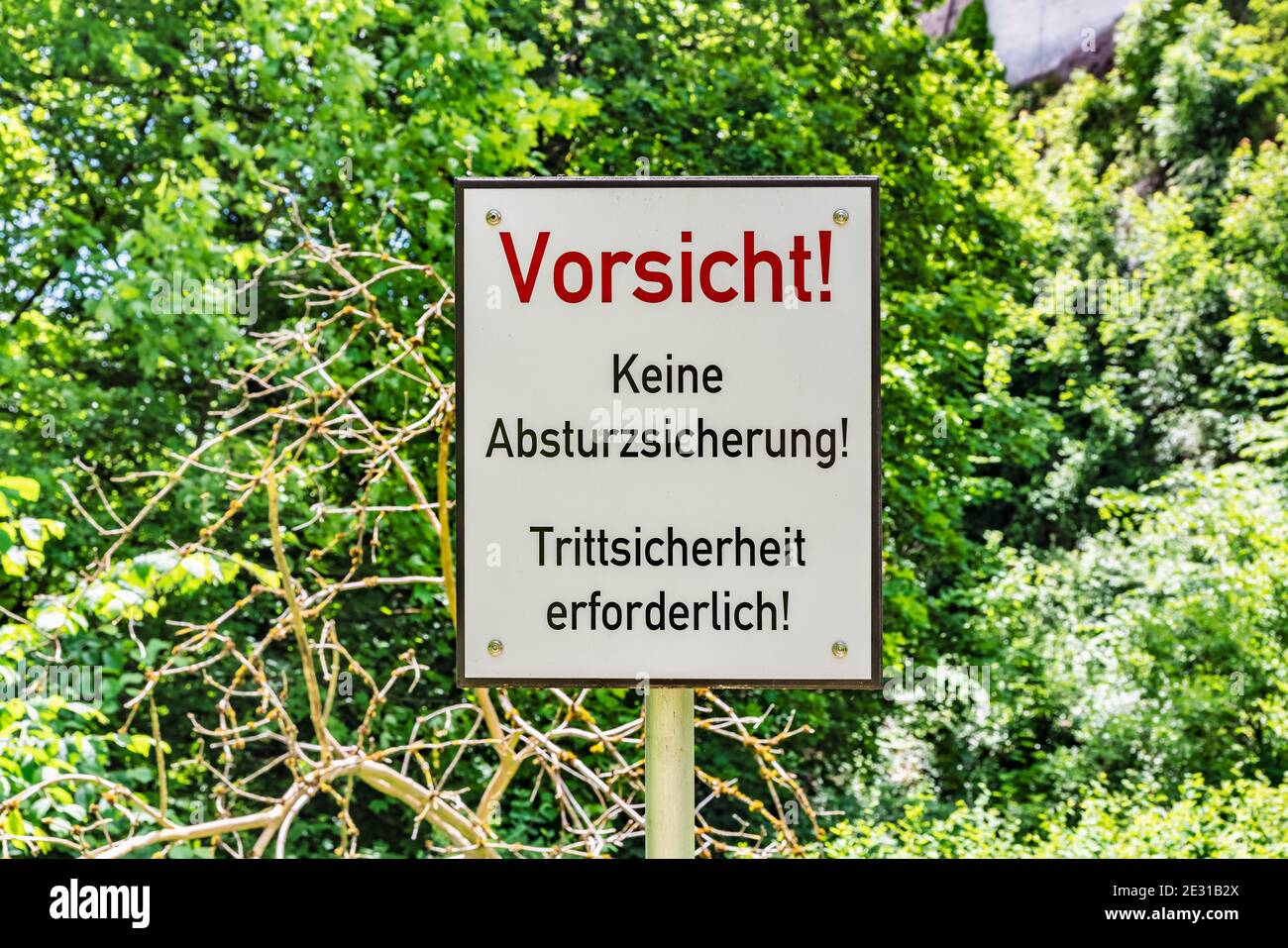 Cartello di avvertimento tedesco con l'iscrizione Vorsicht, keine Asturzsicherung! Tritsicherheit erforderlich! Foto Stock