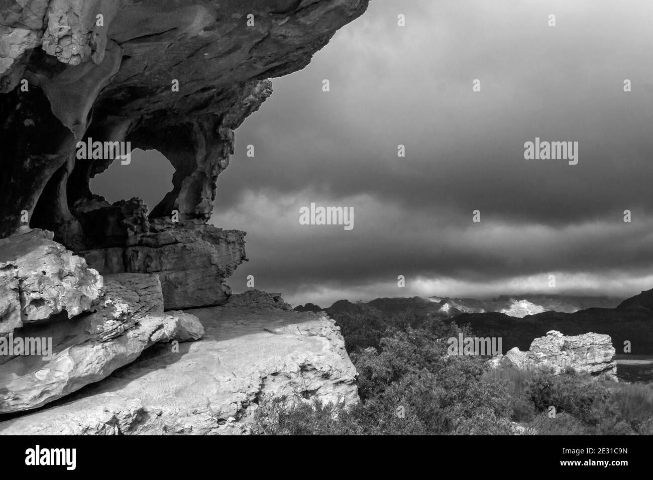 Una colonna di arenaria, situata a formare una finestra naturale nella regione delle grotte di Stadsaal delle montagne di Cederberg in Sud Africa, con il sole che si infrangono Foto Stock