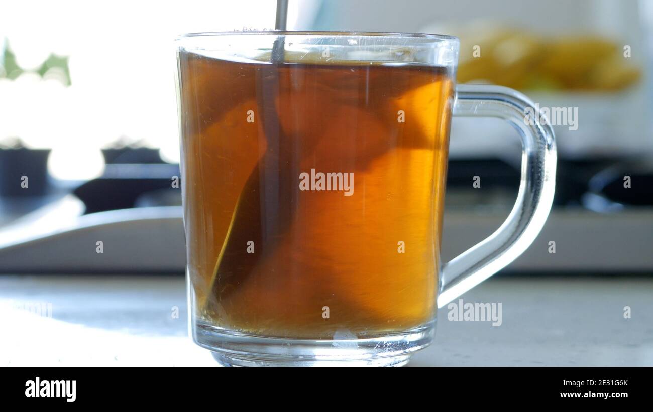 Immagine con la preparazione di un tè caldo e aromatico con zucchero E limone fresco usando le foglie naturali del tè Foto Stock