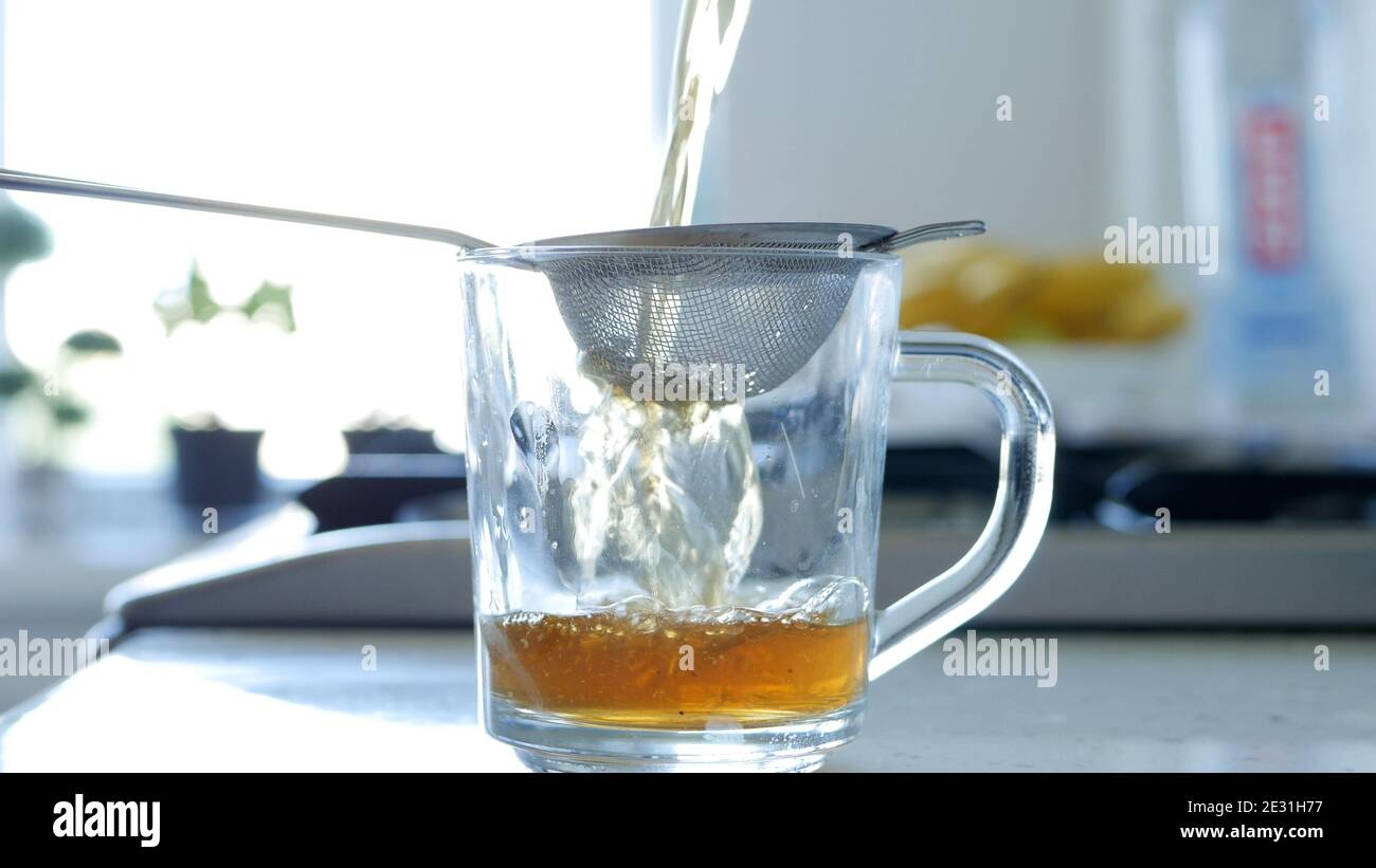 Immagine con la preparazione di un tè caldo e aromatico utilizzando un Succhieruola e foglie di tè naturale Foto Stock