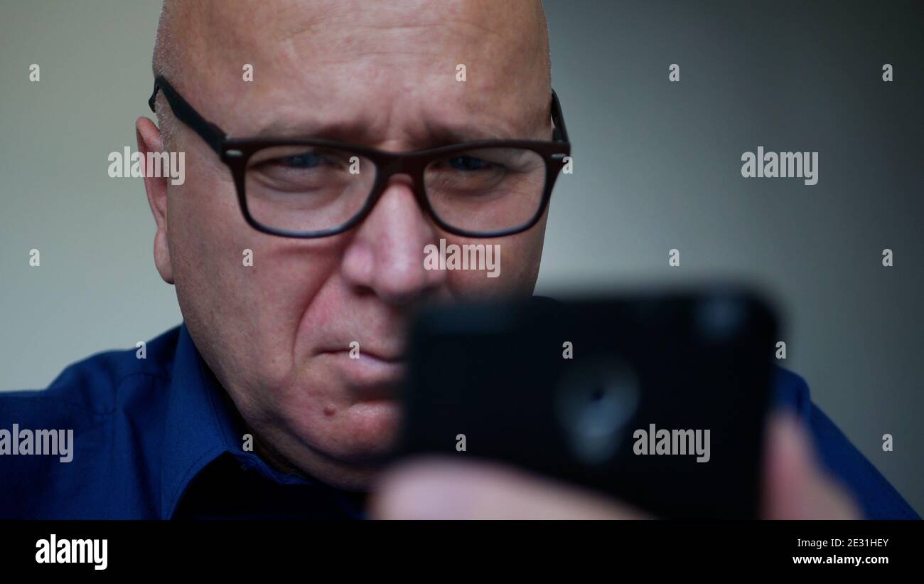 Uomo d'affari inviare un messaggio utilizzando un cellulare, una persona che accede ai social media Foto Stock