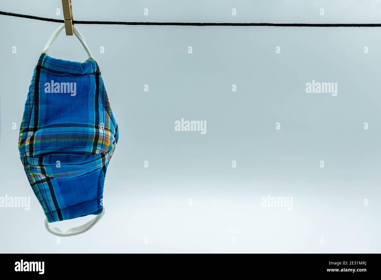 La maschera di stoffa hanging.Hand fatto cotone panno maschera sono l'asciugatura. Maschera per il viso riutilizzabile fatta in casa dopo il lavaggio. Foto Stock