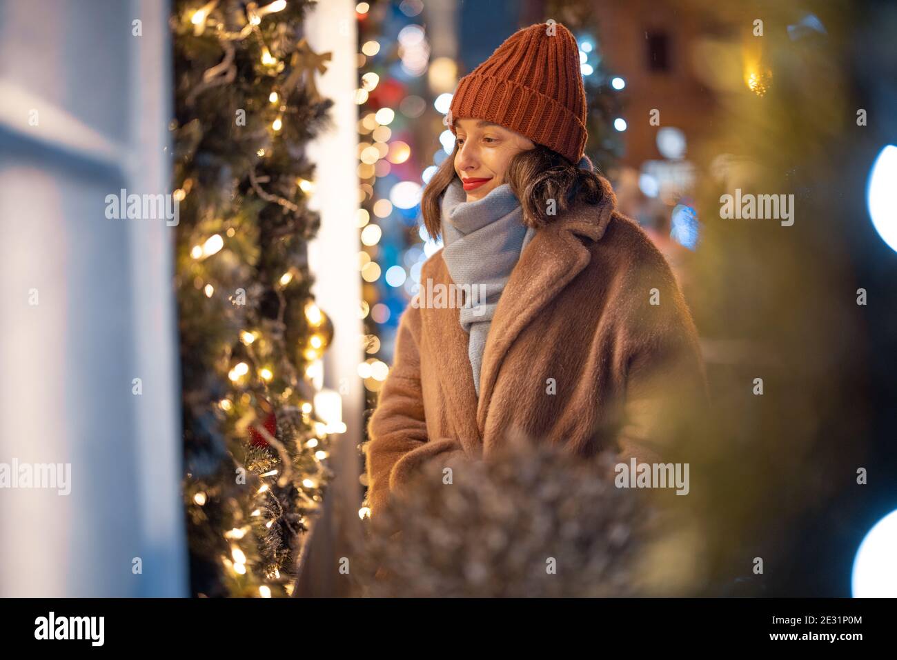 Donna che guarda la vetrina nel mercato di Natale Foto Stock