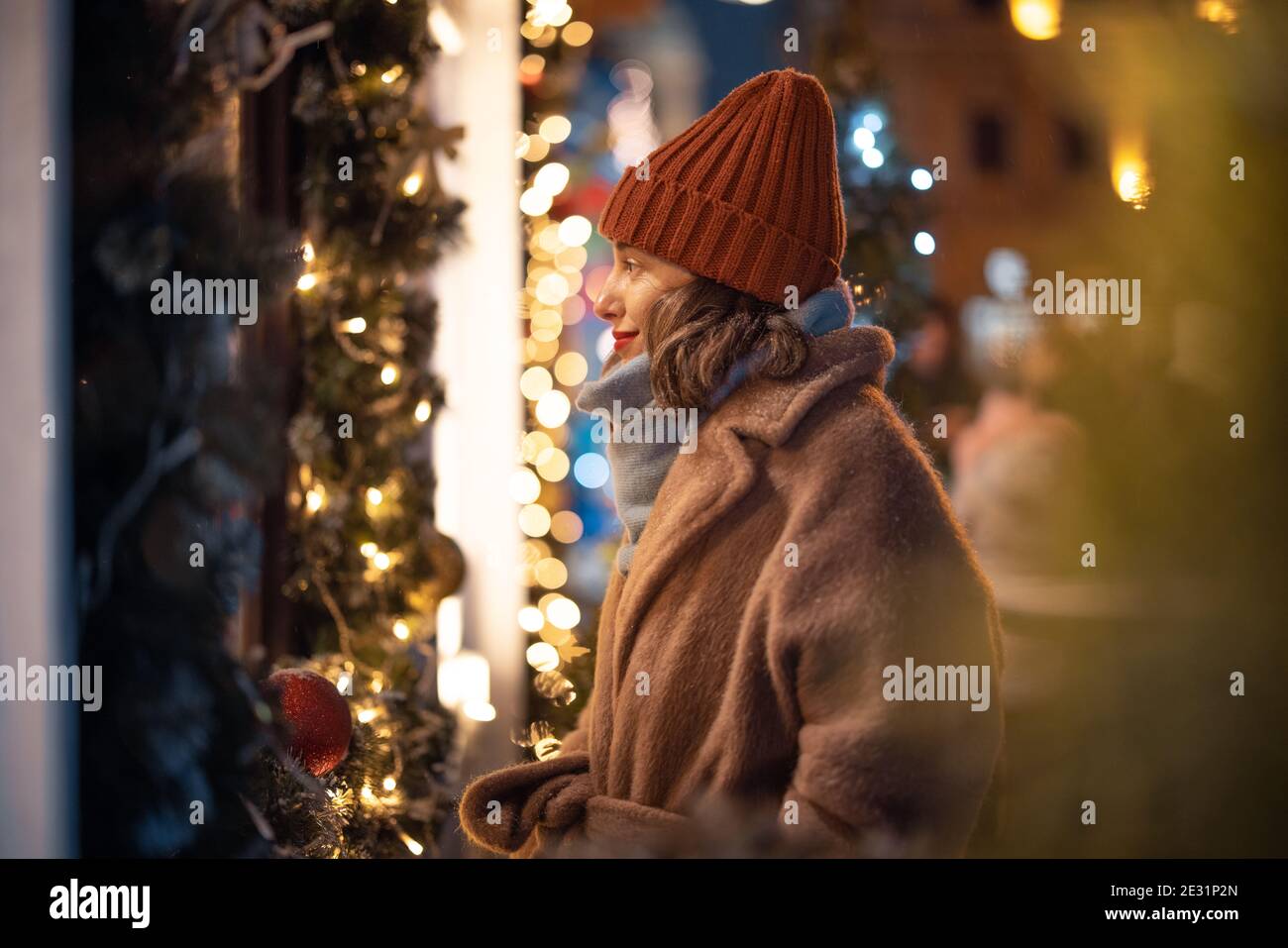 Donna che guarda la vetrina nel mercato di Natale Foto Stock