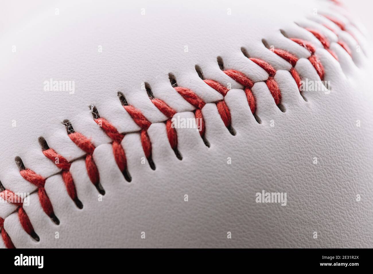 Primo piano di una cucitura a filo rosso su una pelle bianca baseball - scatto macro Foto Stock