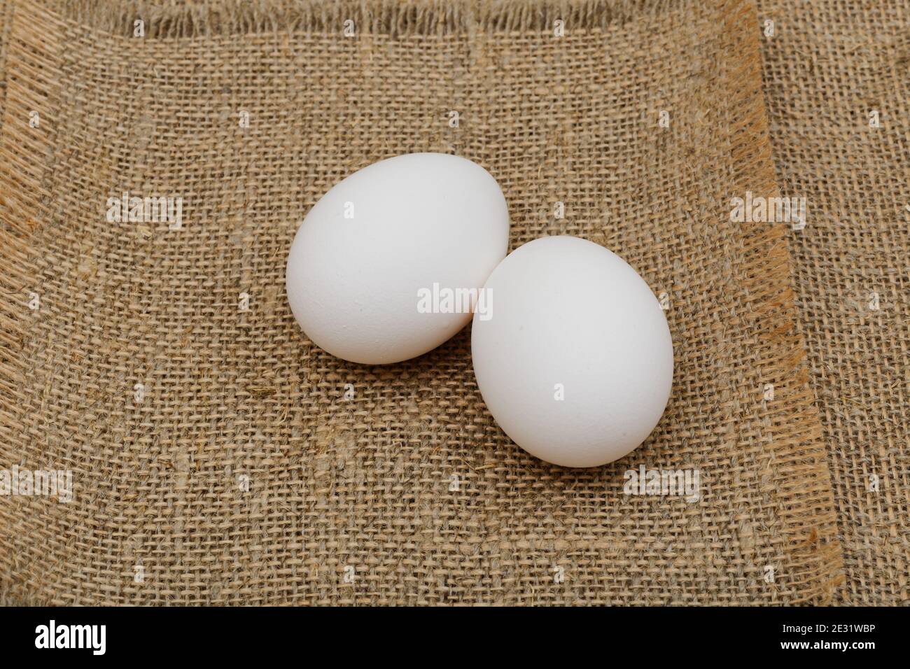 Due uova bianche sul panno morbido Foto Stock