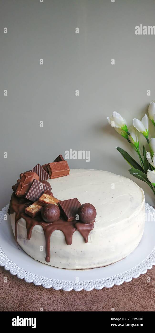 Deliziosa torta fatta in casa su un piatto decorato con caramelle al cioccolato Foto Stock