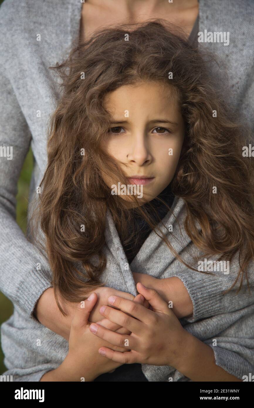 Ragazza ravvicinata tra le braccia di sua madre. Foto Stock