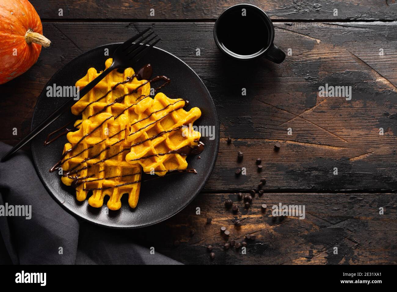 Cialde di zucca con cioccolato e zucchero in polvere su sfondo vecchio scuro. Vista dall'alto Foto Stock