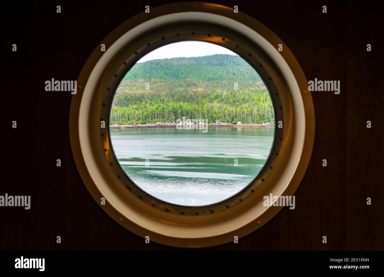 Vista della finestra dell'oblò lungo la crociera Inside Passage, Vancouver Island, British Columbia, Canada. Focus sul paesaggio. Foto Stock