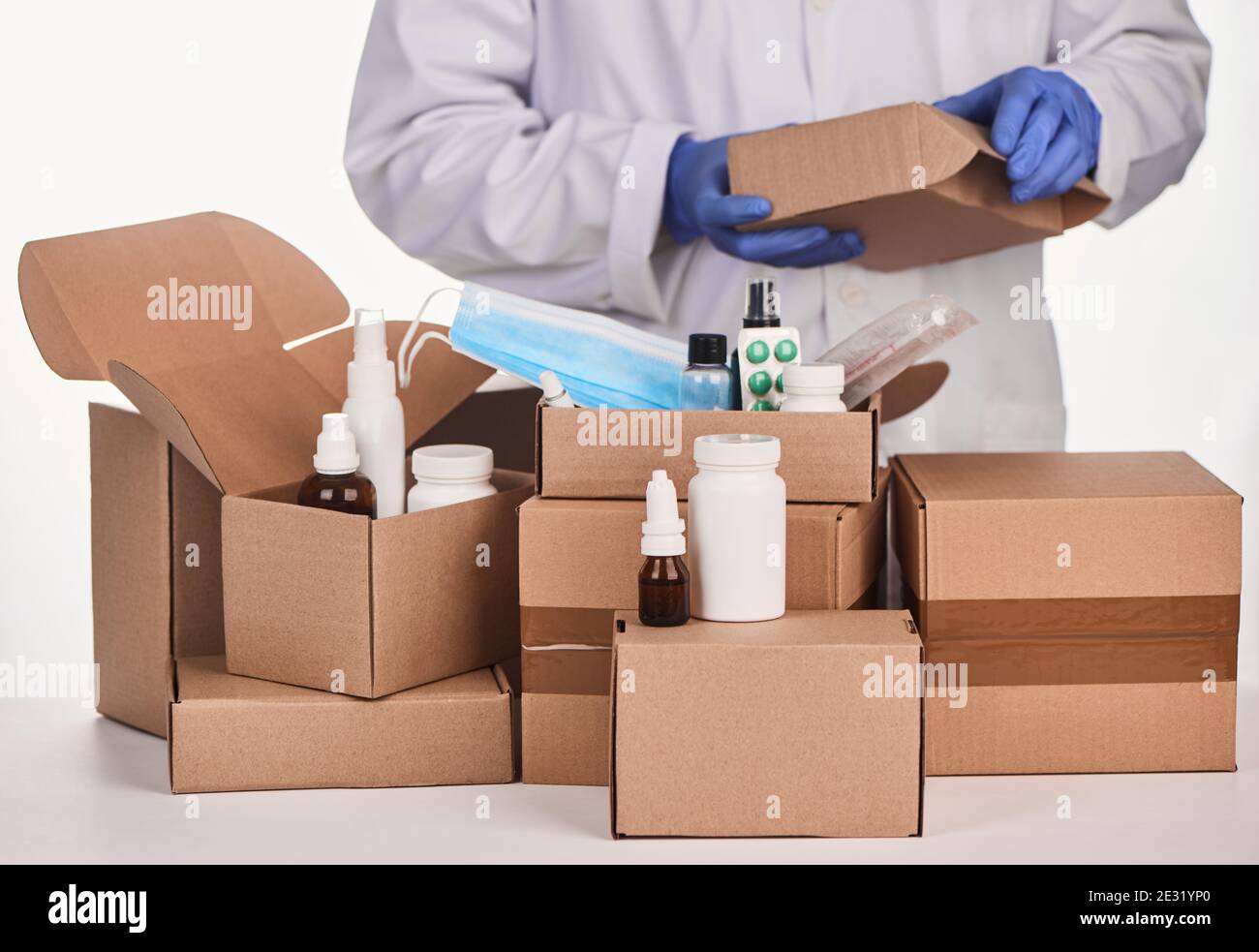 Farmacista che raccoglie i farmaci e li impacchette in pacchi di cartone Foto Stock