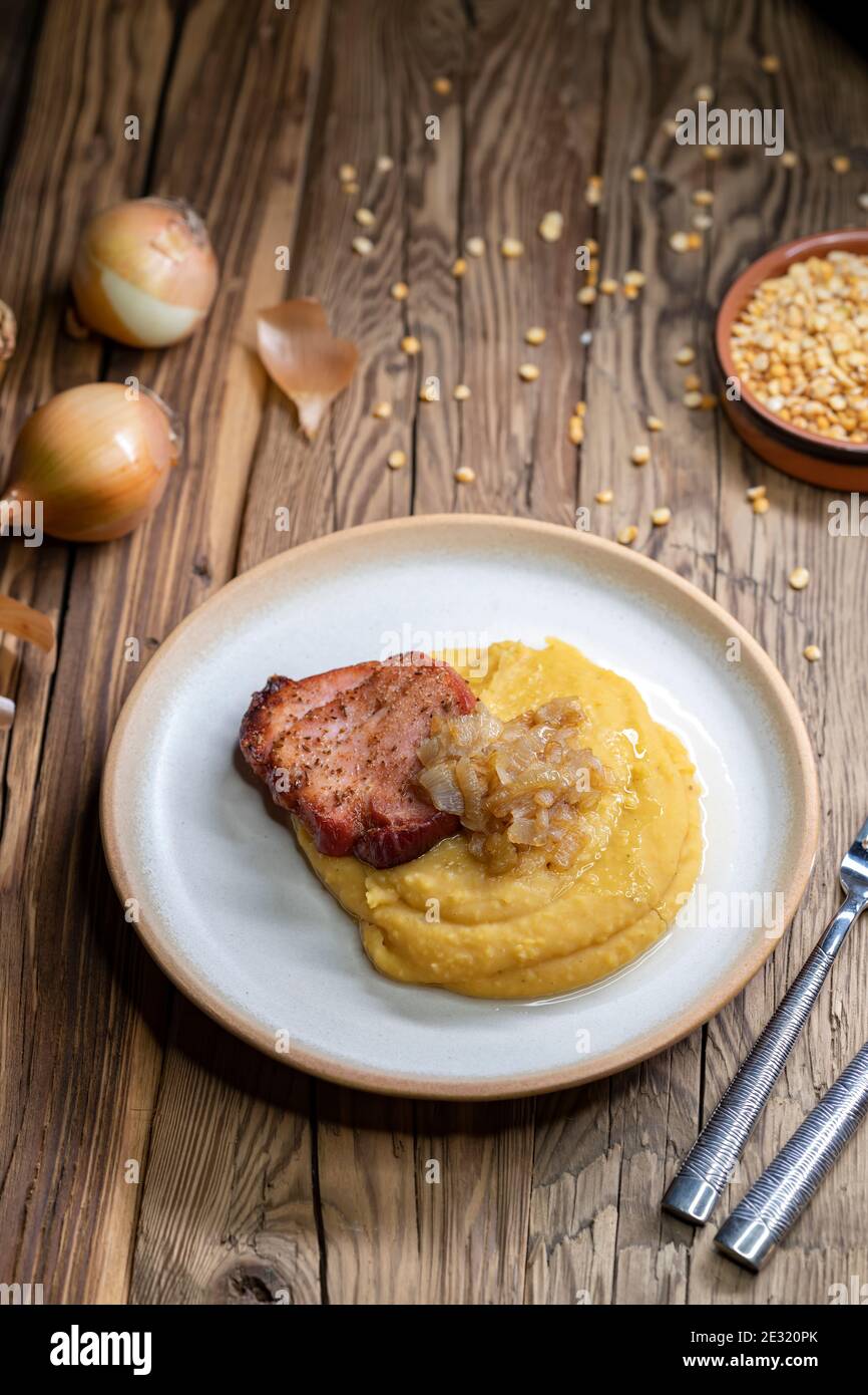 Cucina ceca, carne affumicata con porridge di piselli e cipolla fritta fino a doratura Foto Stock