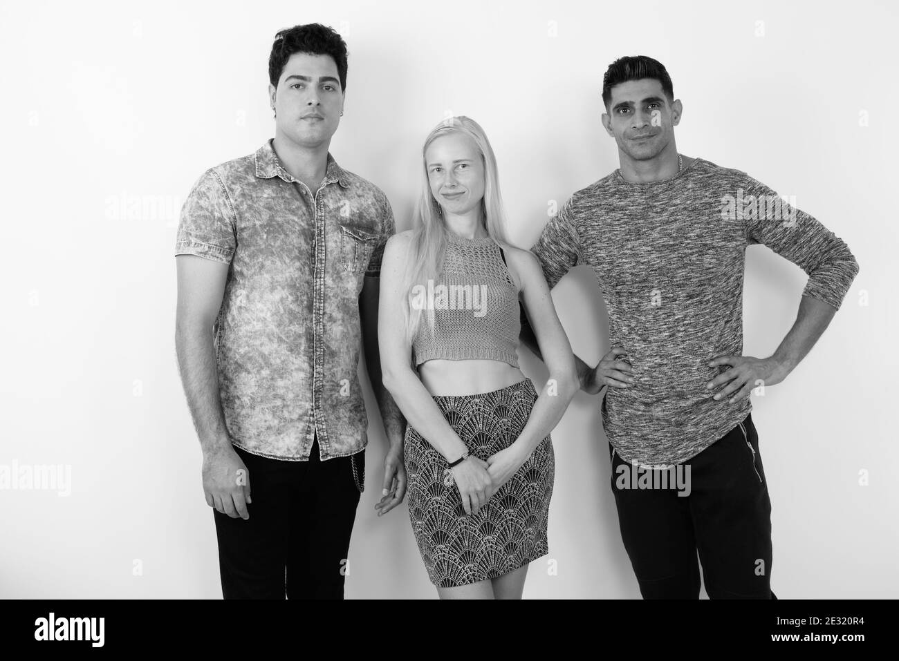 Tre multi-etnico amici insieme contro uno sfondo bianco Foto Stock