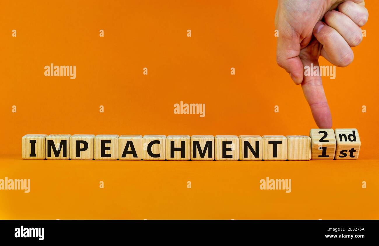 Secondo simbolo di impedimento. L'uomo d'affari trasforma i cubi di legno e cambia le parole 1° impeachment a 2° impeachment. Bellissimo sfondo arancione, copia spac Foto Stock