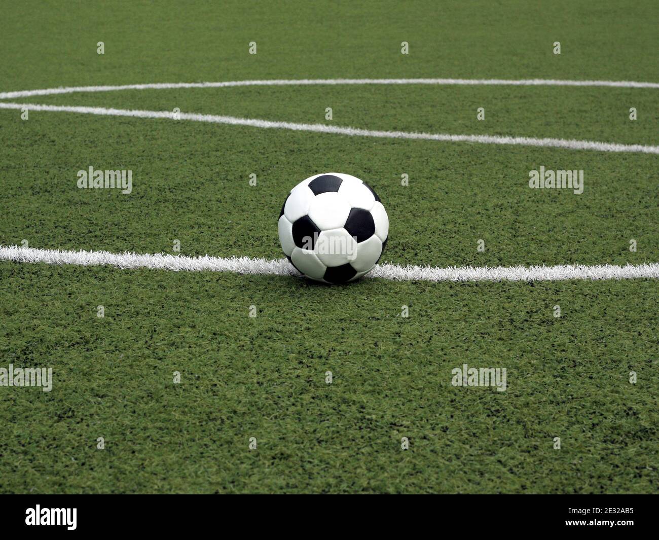 Palla classica per giocare a calcio in bianco con accenti neri si trova su erba  sintetica verde sulla linea di marcatura vicino centro di parco giochi  sportivo Foto stock - Alamy