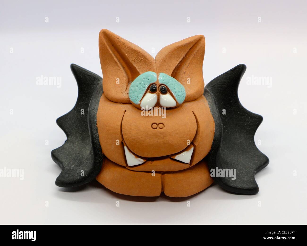 Foto di un cartoncino in ceramica Vampire con un viso marrone simile a un gatto e ali nere su sfondo bianco Foto Stock