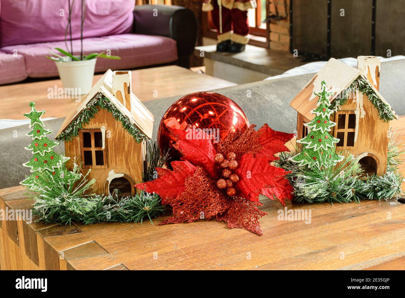 Decorazione di Natale, due mini case di legno e una grande palla rossa. Foto Stock