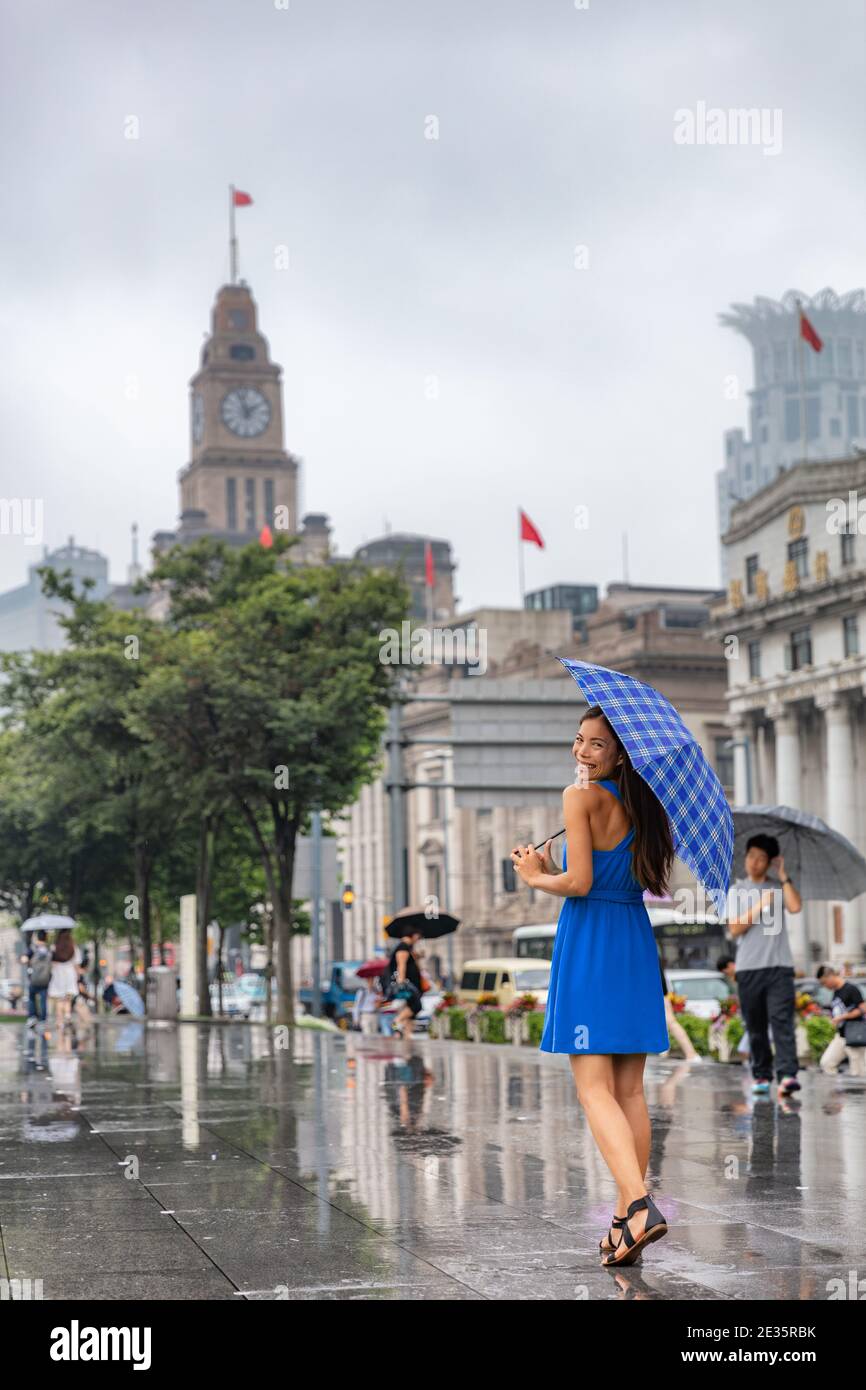 Cina viaggio turista donna a piedi nella città di Shanghai sotto la pioggia con ombrello. Donna asiatica a piedi dal fiume Bund felice passeggiata sul viaggio Asia Cina Foto Stock