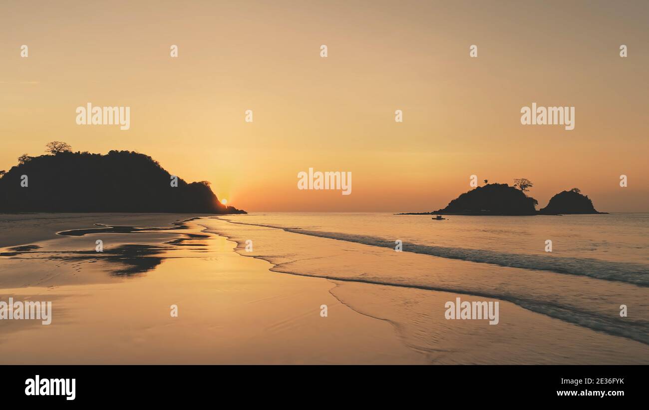 Silhouette tramonto di montagne isole a mare baia. Tropic Seascape sulla spiaggia di sabbia. Nessuno paesaggio naturale della spiaggia di sabbia dell'oceano. El Nido Isle, Filippine, Asia alla sera d'estate. Colpo morbido del drone Foto Stock