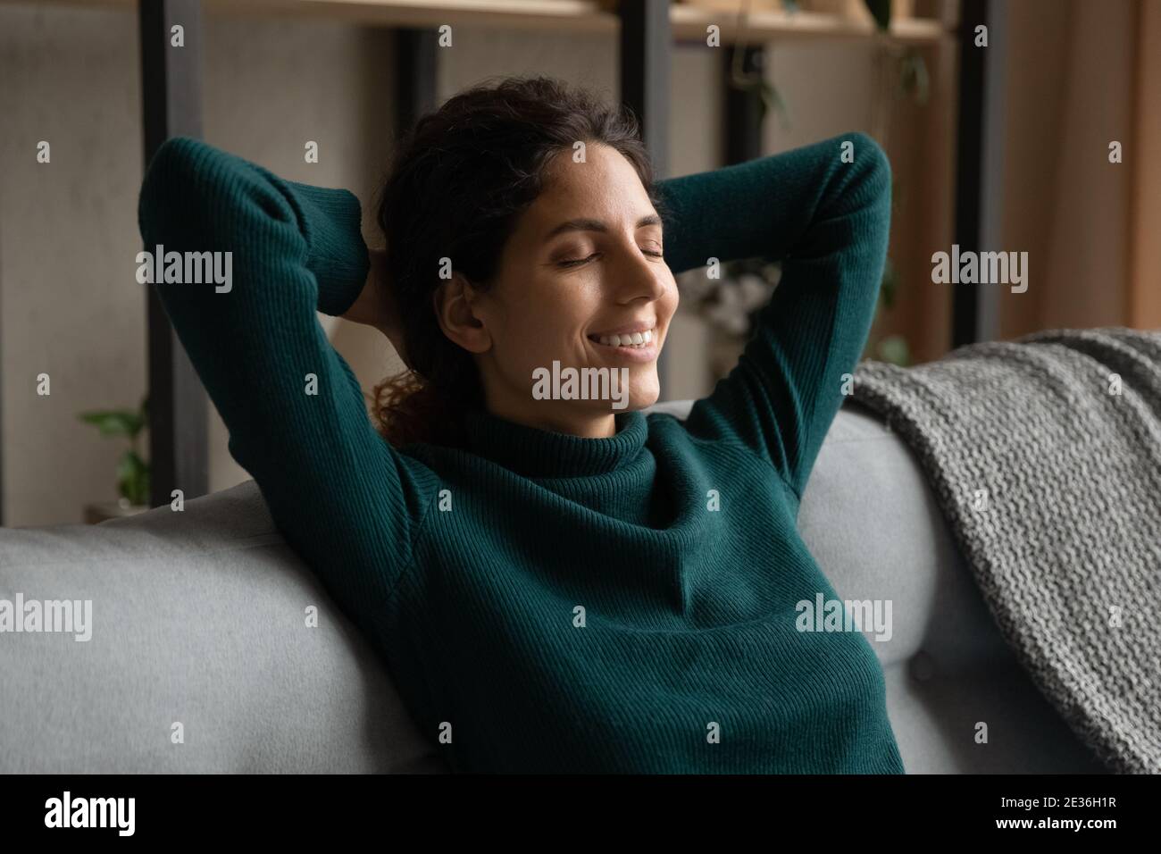 Calma giovane donna rilassarsi a casa daydreaming Foto Stock