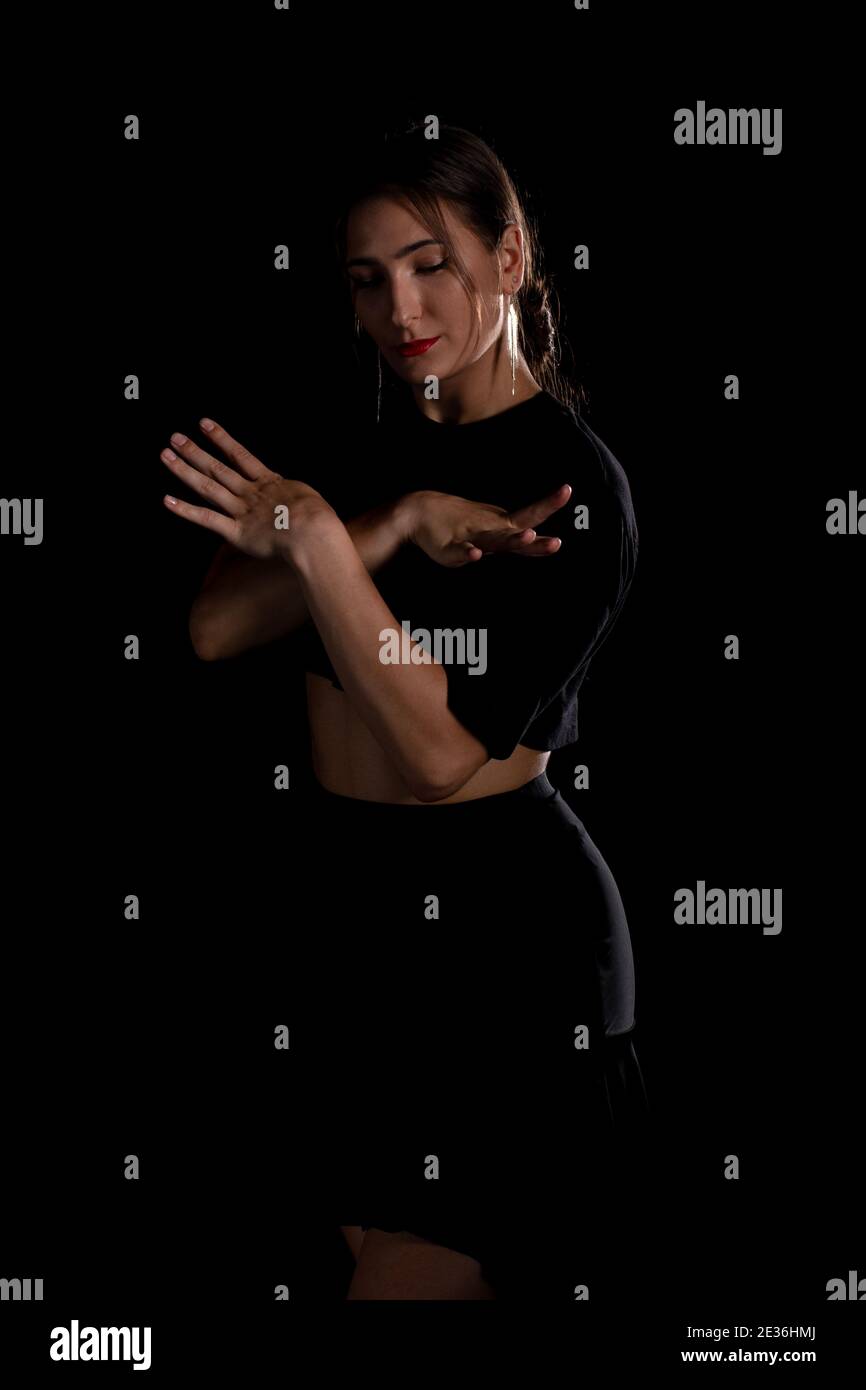 Giovane ballerina professionista che pratica in uno studio, giovane donna in un vestito nero danzante, ballerina Foto Stock