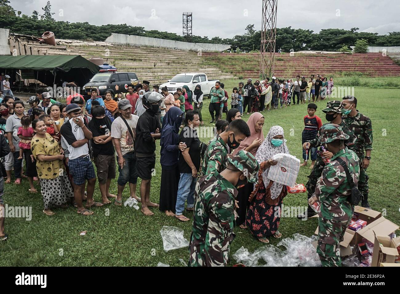 Mamuju, Sulawesi Occidentale, Indonesia. 17 gennaio 2021. I rifugiati che sono stati vittime del terremoto nella città di Mamuju si sono riuniti allo stadio di calcio di Manakarra per ricevere aiuti sotto forma di cibo e abbigliamento. Centinaia di residenti sono stati costretti a vivere in tende rifugiate dopo che le loro case sono state distrutte dal terremoto del 6.2 del maghnetudo che si è verificato nella zona di Mamuju, Sulawesi occidentale, Indonesia. Credit: Herwin Bahar/ZUMA Wire/Alamy Live News Foto Stock