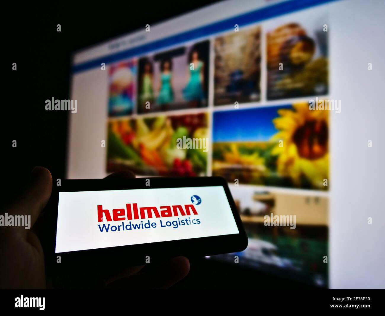 Telefono cellulare con logo della multinazionale tedesca Hellmann Worldwide Logistics. Concentrarsi sulla parte sinistra dello schermo dello smartphone. Foto originale. Foto Stock
