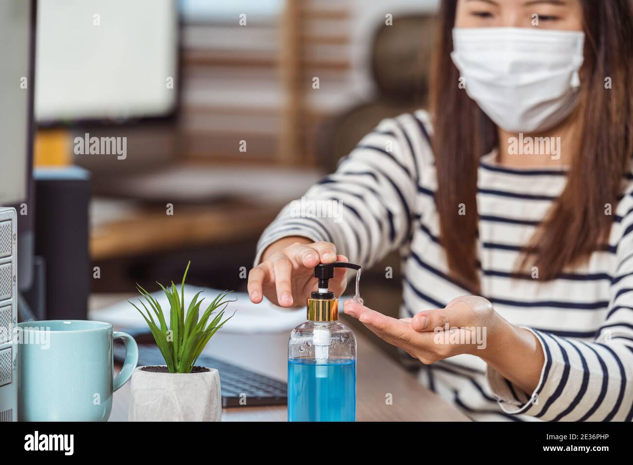 Closeup Asian donna operaio disinfettante per le mani per la pulizia della sua mano quando lavora con il computer in ufficio domestico quando Covid-19 pandemic, focolaio di Coronavirus, Foto Stock Closeup Asian donna operaio disinfettante per le mani per la pulizia della sua mano quando lavora con il computer in ufficio domestico quando Covid-19 pandemic, focolaio di Coronavirus, Foto Stock