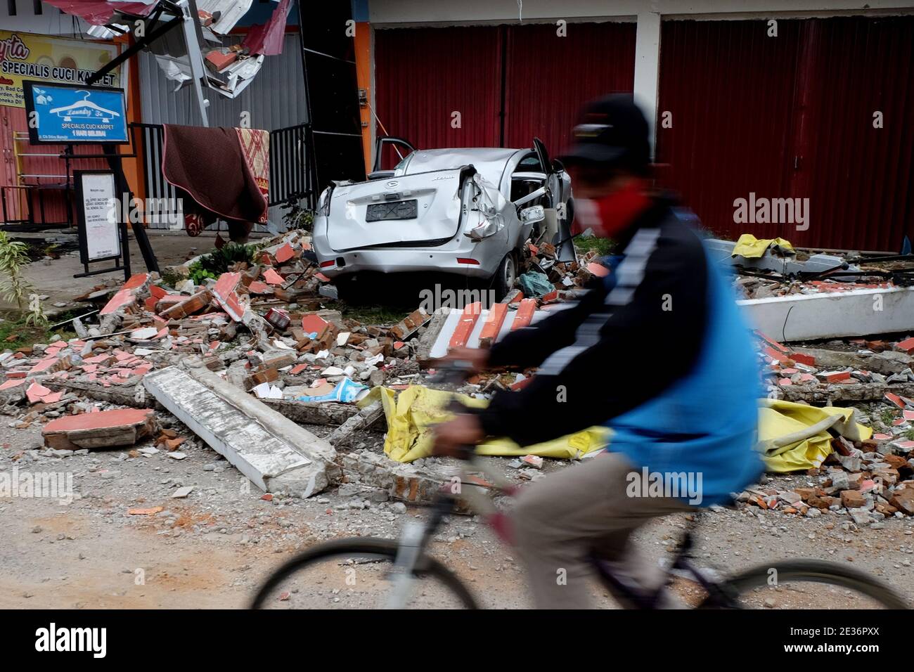 Mamuju, Indonesia. 17 gennaio 2021. I residenti passano attraverso l'area delle macerie dopo il terremoto di magnitudine 6.2 a Mamuju City, Sulawesi Ovest. (Foto di Zul Kifli/Pacific Press) Credit: Pacific Press Media Production Corp./Alamy Live News Foto Stock