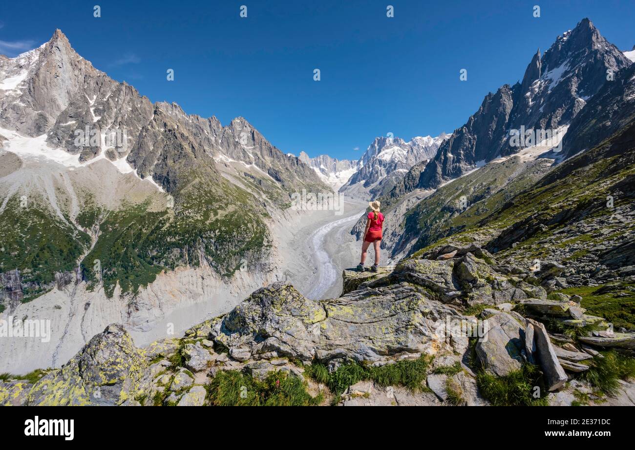 Scalatore in piedi su rocce, Grand Balcon Nord, lingua del ghiacciaio Mer de Glace, dietro Grandes Jorasses, massiccio del Monte Bianco, Chamonix, Francia Foto Stock