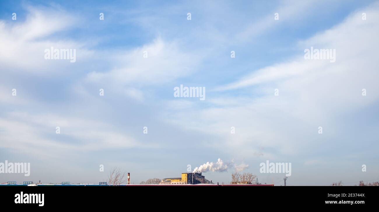 Fumo bianco spesso dal camino del locale caldaia. Fumo contro il cielo blu. Inquinamento atmosferico. Riscaldamento della città. Zona industriale. Foto Stock