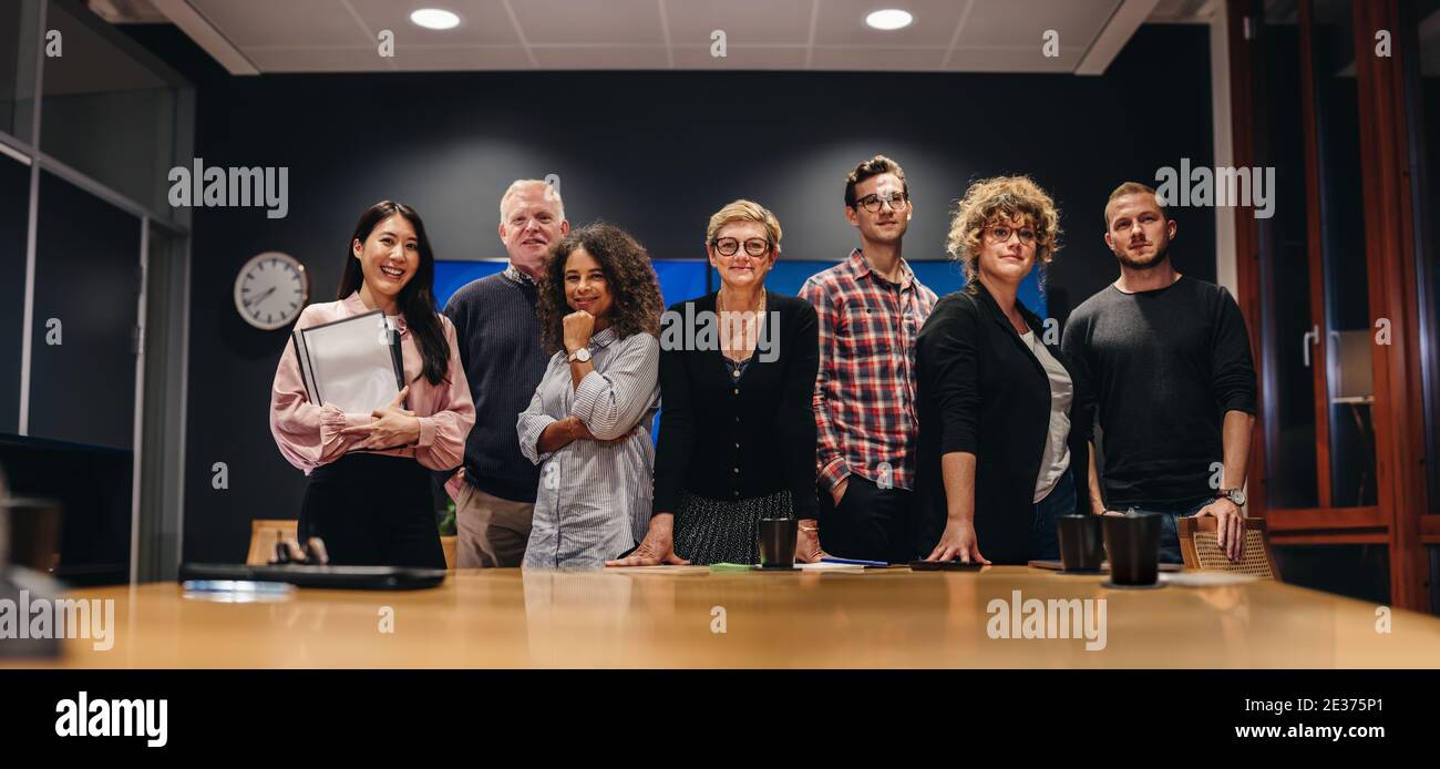 Gruppo di giornalisti televisivi in piedi al tavolo delle conferenze. uomini d'affari nella sala riunioni. Foto Stock
