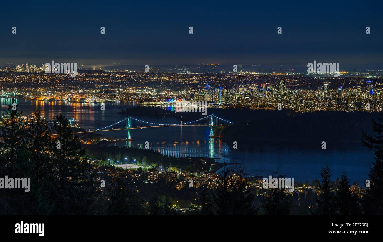 Vista panoramica del paesaggio urbano di Vancouver, tra cui il punto di riferimento architettonico Lions Gate Bridge e gli edifici del centro città di notte, British Columbia, Canada. Foto Stock