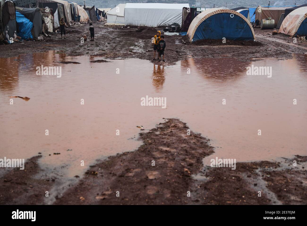 Kafr Aruq, Siria. 17 gennaio 2021. I bambini siriani si trovano nel campo allagato di tal Amin per gli sfollati interni, vicino al villaggio di Kafr Aruq. I campi profughi nel nord del governatorato dell'Idlib sono stati minacciati da condizioni climatiche estreme in quanto sono stati allagati a seguito di forti piogge nei giorni precedenti. Credit: ANAS Alkharboutli/dpa/Alamy Live News Foto Stock