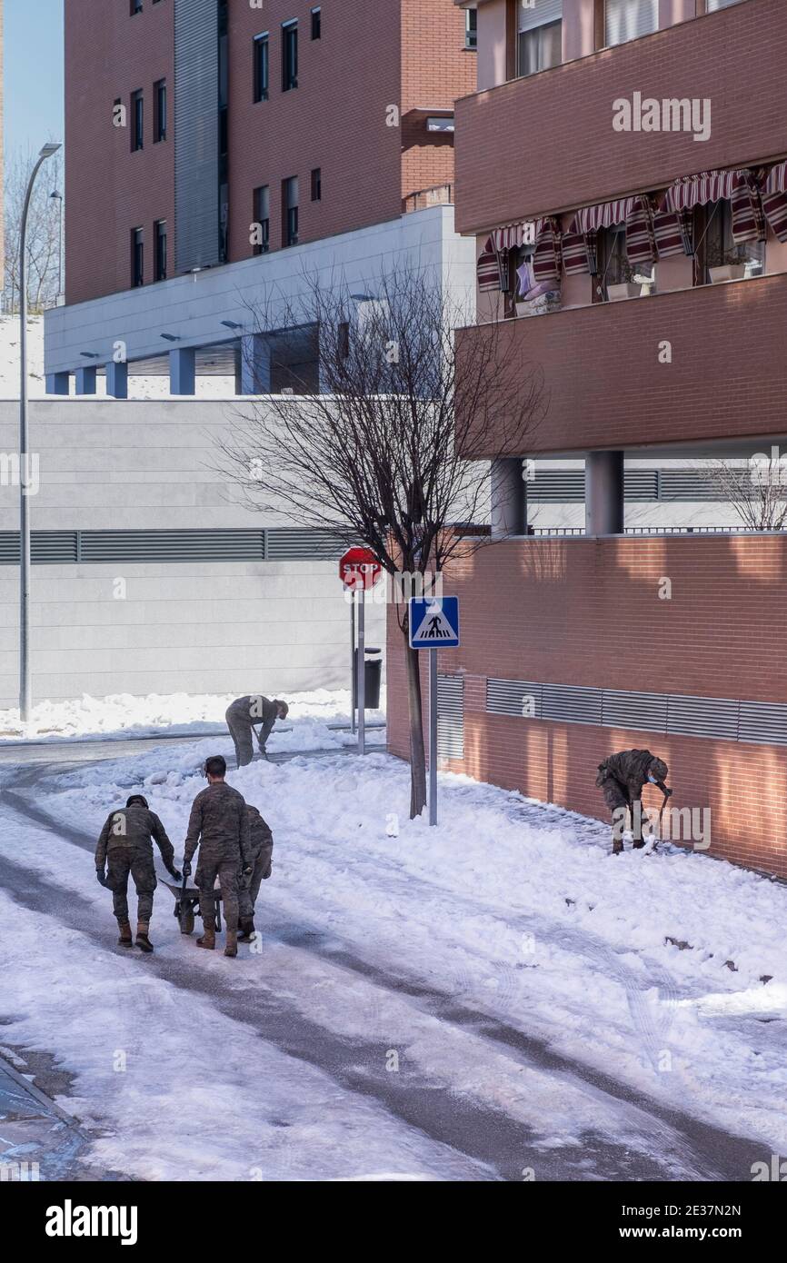 I soldati dell'esercito puliscono le strade di neve con pale e spalmano sale per evitare il congelamento dopo la tempesta di neve Filomena, verticale Foto Stock