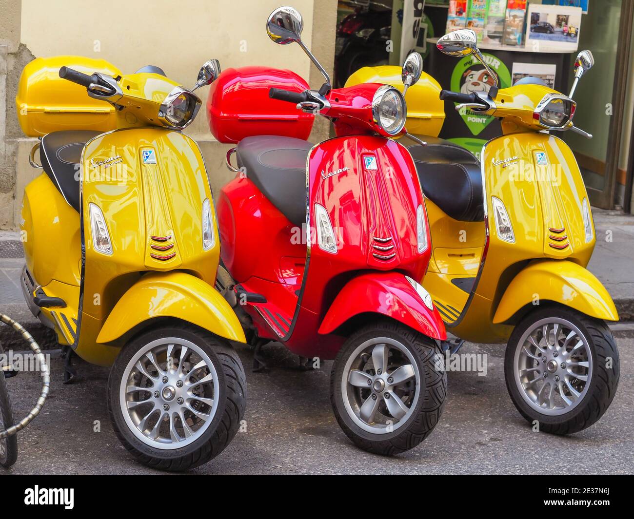 Due scooters gialli Vespa Sprint 150 Sport e rossi Vespa Primavera 150 si trovano sulla via di Firenze. Marca italiana di scooter prodotta da Piaggio. Foto Stock