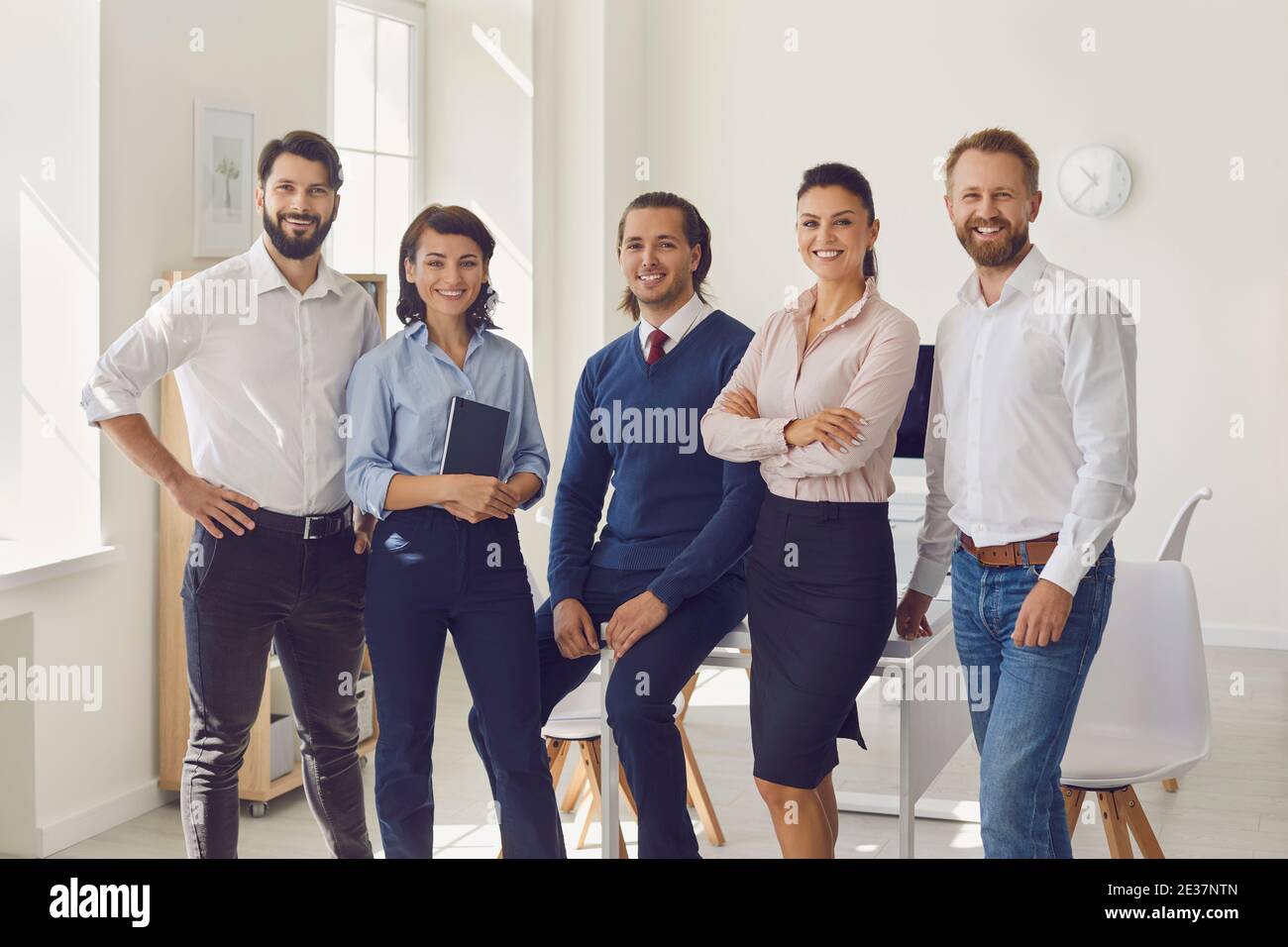 Gruppo di giovani uomini d'affari sorridenti che guardano alla telecamera discussione di successo del progetto Foto Stock