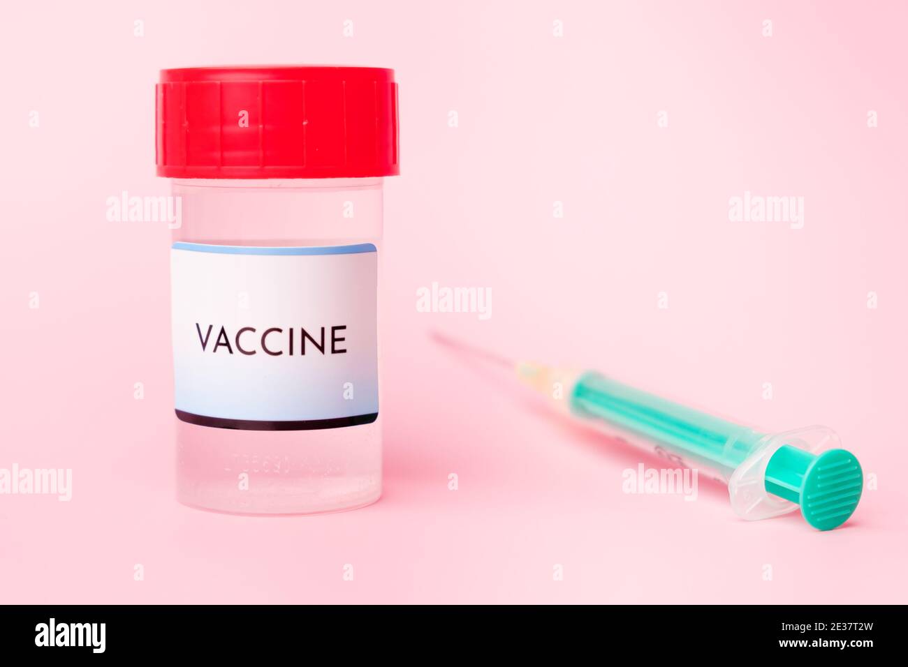 Vaccino Covid-19 nel flacone e siringa monouso per iniezione su fondo rosa. Prevenzione del coronavirus, Sars-Cov-2. Foto Stock
