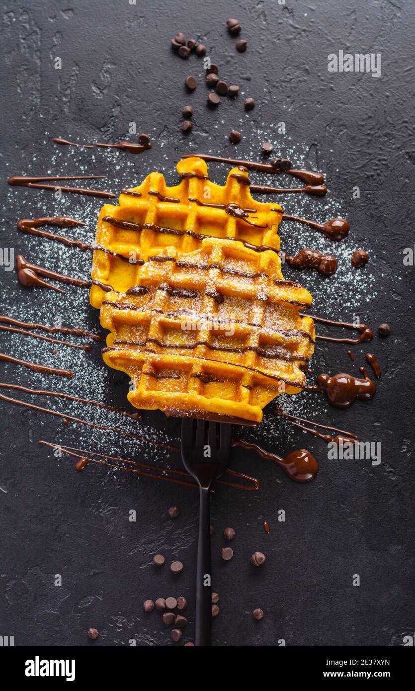 Cialde di zucca con cioccolato e polvere di zucchero strung su fondo vecchio scuro forkon. Vista dall'alto Foto Stock