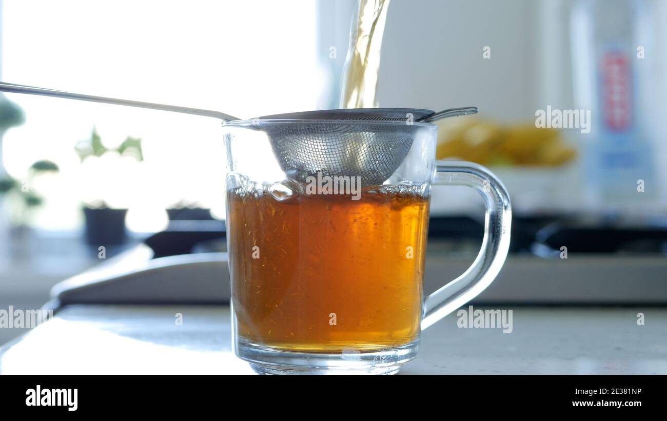 Immagine con la preparazione di un tè caldo e aromatico utilizzando un Succhieruola e foglie di tè naturale Foto Stock